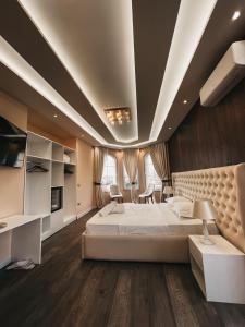 una camera da letto con un grande letto bianco e pavimenti in legno di Amansar Boutique Hotel a Tirana