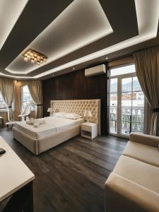 a bedroom with a large bed and a large window at Amansar Boutique Hotel in Tirana