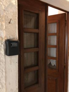 a wooden door with a clock on a wall at Palaia katoikia Amazing View Pyrgos Santorini in Pyrgos