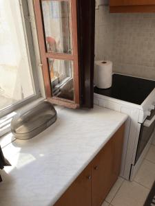 a kitchen counter with a sink and a window at Palaia katoikia Amazing View Pyrgos Santorini in Pyrgos