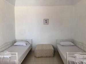 two beds in a room with white walls at Palaia katoikia Amazing View Pyrgos Santorini in Pyrgos