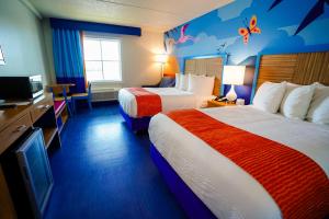 a hotel room with two beds and a tv at Castaway Bay by Cedar Point Resorts in Sandusky