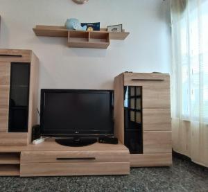a flat screen tv sitting on a wooden entertainment center at Apartment Riba in Ankaran