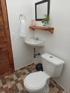 a bathroom with a white toilet and a sink at Alas Glamping La Cima in Guatavita