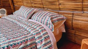 a bed with a colorful blanket and a pillow at Alas Glamping La Cima in Guatavita