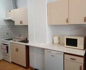 cocina con armarios blancos y microondas en Apartment Riba, en Ankaran