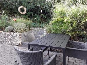 a black table and chairs in a garden at Apartment am Gifizsee Offenburg in Offenburg