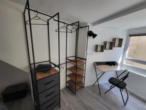 Cette chambre comprend un bureau, une étagère et une table. dans l'établissement Superbe appartement T2 centre historique, à La Souterraine