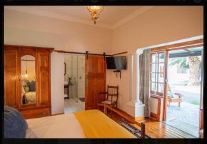 1 dormitorio con 1 cama y puerta corredera de cristal en Die Hof Gastehuis, en Kroonstad