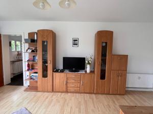een woonkamer met houten meubels en een flatscreen-tv bij Ferienwohnungen Waldblick in Remscheid