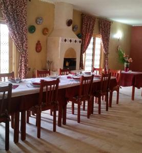 a large dining room with a long table and chairs at AUBERGE DES ANGES in Zrigat