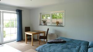 a bedroom with a desk and a bed and a table at Ferienwohnung Eifelbergblick mit Garten, Schleiden, Wandern in the Eifel National Park, nähe Rursee in Schleiden