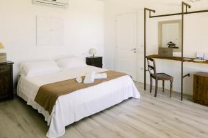 a white bedroom with a bed and a desk at Luce in Magione