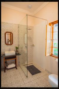 a bathroom with a glass shower and a sink at Die Hof Gastehuis in Kroonstad