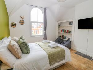 a bedroom with a large bed and a window at The Bookcase in Colwyn Bay