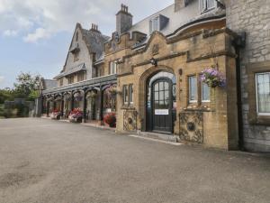 an old stone building with flowers on the windows at Harcombe House Bungalow 9 in Newton Abbot