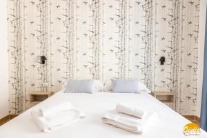 1 dormitorio con 1 cama blanca y 2 toallas en La Luz de la Viña - FREE PARKING by Cadiz Time en Cádiz