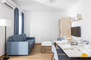 une salle à manger avec une table et un canapé bleu dans l'établissement La Luz de la Viña - FREE PARKING by Cadiz Time, à Cadix
