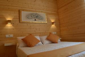 a bedroom with a bed in a wooden wall at Cabañas Compostela - Cabaña a Carballeira in Santiago de Compostela