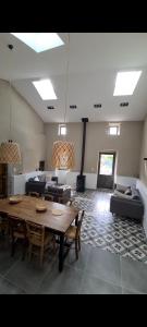 a living room with a wooden table and couches at Magnifique maison en coeur de Balazuc, proche plages ardèche in Balazuc