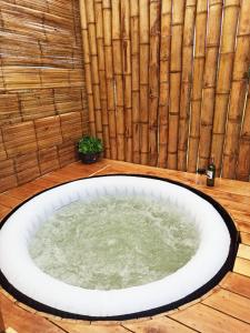 bañera de hidromasaje en una habitación con pared de bambú en Alas Glamping La Cima, en Guatavita