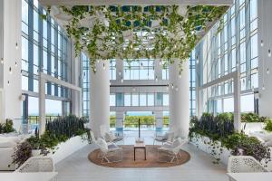 a large lobby with white chairs and plants at Sentral Michigan Avenue in Chicago
