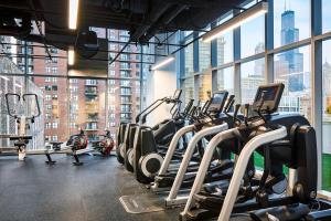 un gimnasio con filas de máquinas cardiovasculares frente a las ventanas en Sentral Michigan Avenue, en Chicago