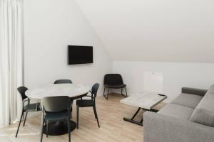 sala de estar con mesa, sillas y sofá en SK67 Stylish and Full Equipped loft with free parking en Lidingö