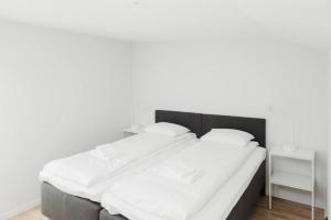 a bedroom with a large bed with white sheets at SK67 Stylish and Full Equipped loft with free parking in Lidingö