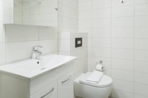 a white bathroom with a sink and a toilet at SK67 Stylish and Full Equipped loft with free parking in Lidingö