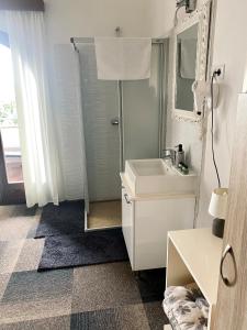 a white bathroom with a sink and a mirror at Hotel Villa Vrsar in Vrsar