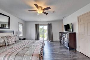 1 dormitorio con 1 cama y ventilador de techo en 5 BR Mansion with Pool and non-heated Jacuzzi Games in Boynton Beach, en Boynton Beach