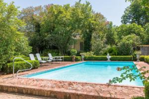 a swimming pool in a yard with chairs and trees at The Burn Bed and Breakfast in Natchez