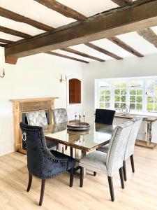 a dining room with a wooden table and chairs at The Farm Exclusive Hire in Stapleford Tawney