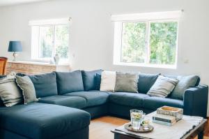 um sofá azul numa sala de estar com uma mesa em Just Like Home - Casa do Sobreiro Velho em Cerveira em Vila Nova de Cerveira