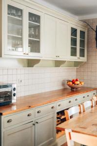 uma cozinha com armários brancos e uma taça de fruta em Just Like Home - Casa do Sobreiro Velho em Cerveira em Vila Nova de Cerveira