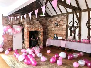 Pokój z różowymi i białymi balonami na podłodze w obiekcie The Farm Exclusive Hire w mieście Stapleford Tawney