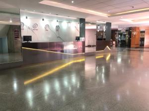 an empty lobby with a shiny floor in a building at ABC Apart Hotel in Brasília