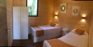 Habitación con 2 camas en una habitación de madera en Cabañas Compostela - Cabaña Bosque Encantado, en Santiago de Compostela