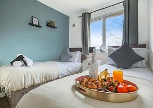 a room with two beds with a tray of food on a table at Walnut House - Close to City Centre - Free Parking, Fast Wifi and Smart TVs by Yoko Property in Milton Keynes