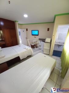 um quarto de hotel com duas camas e uma televisão em CTC Araras Centro em Caldas Novas