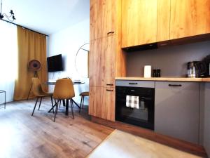 a kitchen with a stove and a table with chairs at PODWALE Apartment - Self Check-In 24h in Wrocław