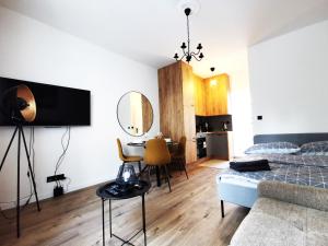 a bedroom with a bed and a table and a dining room at PODWALE Apartment - Self Check-In 24h in Wrocław