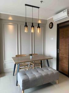 a dining room with a table and chairs and lights at Daymentroom R32 Apartemen 2 BR Pasteur Bandung in Bandung