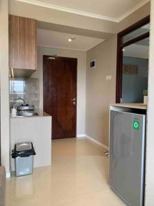a kitchen with a refrigerator and a door in it at Daymentroom R32 Apartemen 2 BR Pasteur Bandung in Bandung