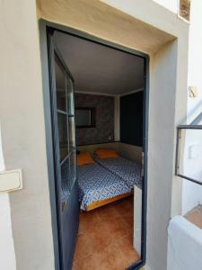 ein kleines Schlafzimmer mit einem Bett in einem Zimmer in der Unterkunft Casa14 in Frigiliana