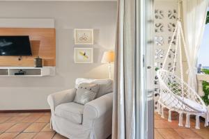 ein Wohnzimmer mit einem Stuhl und einem TV in der Unterkunft Tres Sirenas Beach Inn in Rincon