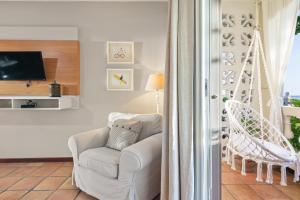 a living room with a chair and a tv at Tres Sirenas Beach Inn in Rincon