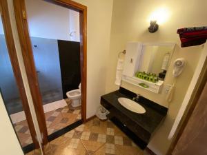 a bathroom with a sink and a toilet and a mirror at Mirante Praia Hotel in Olímpia