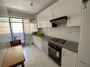 a kitchen with white cabinets and a stove top oven at piso para jovenes familia cerca playa y centro . BLASCO IBANEZ A in Valencia